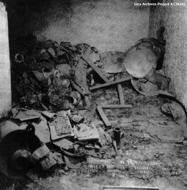 From this view of the tomb the disintegrated bed can be barely discerned amid the rubble. The regular inlays of the footboard can be seen in the lower right of the picture, but otherwise the positions of the metal fittings had to be noted to determine where the wooden elements would have fitted together (Giza Archives Project A 3824).