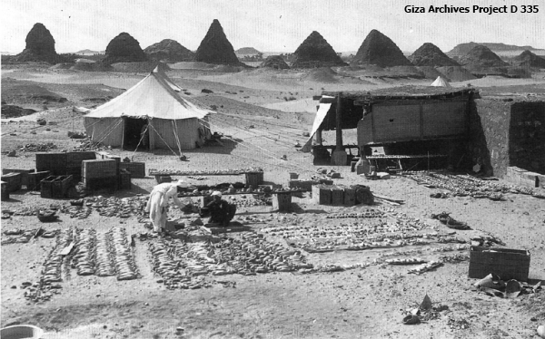 Workmen sorting royal shabti figures at Nuri, Sudan, with the pyramids in the background, March 19, 1917 (Giza Archives Project D 335)